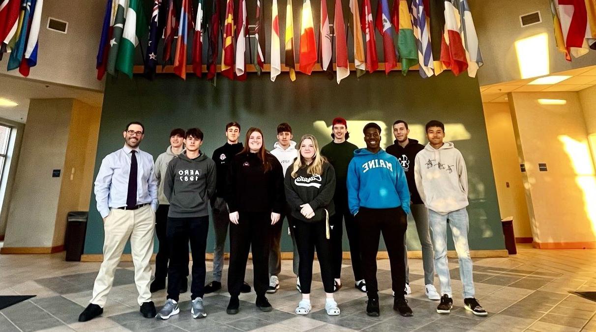 网上网赌平台大学 international students posing with Luke Shorty in the Hall of Flags